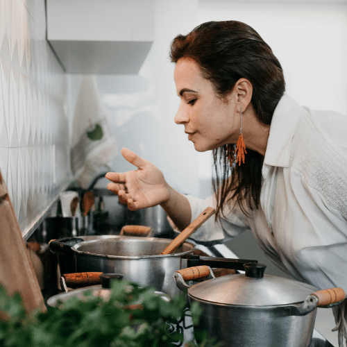 Camille aux fourneaux – la simplicité en action Camille prépare un plat maison dans sa cuisine, concentrée et souriante