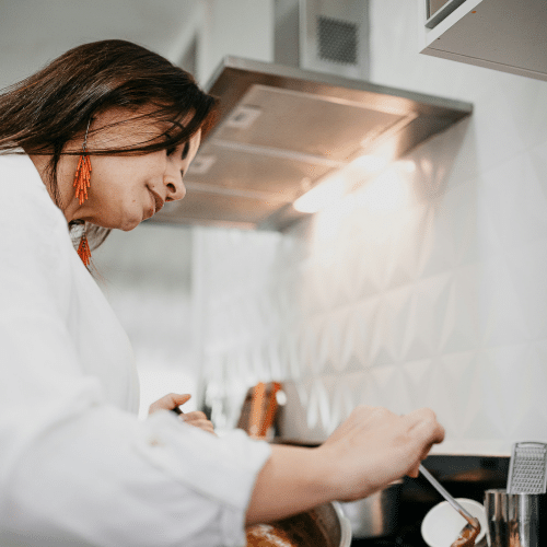 Camille dans un moment de réflexion culinaire, entourée de produits frais